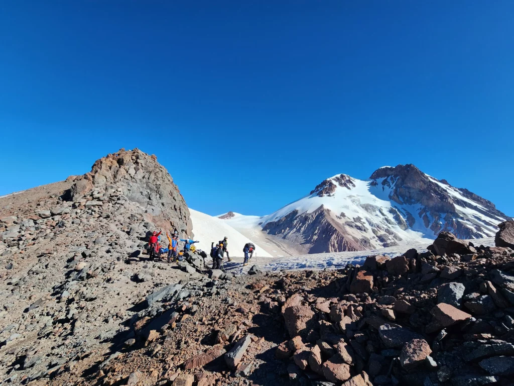 Group of climbers taking rest under the sun with view of Mt. Kazbek