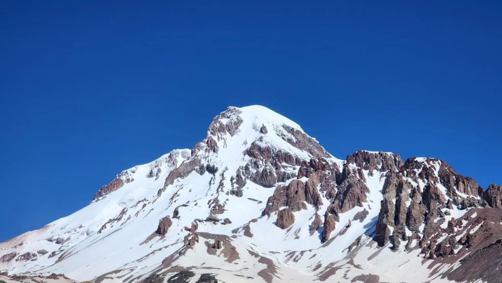 Mount Kazbek peak viewed from Gergeti Glacier under a clear sunny sky
